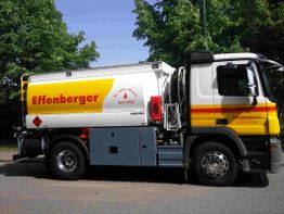 Tankwagen mit gelber Werbung "Effenberger", von Bäumen umgeben, steht auf einer Straße.