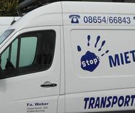 Weiße Transporter mit Aufschrift "Miet mich!" und Preisangebot, in einer Reihe geparkt.