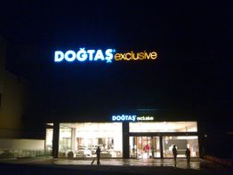 Großes, beleuchtetes Möbelgeschäft mit der Aufschrift "Doğtaş Exclusive" in der Nacht.