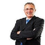 Man in a suit with crossed arms, smiling against a white background.