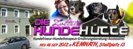 Gebäude mit "Die Zottelige Hundehütte"-Werbung, Frau, Auto und drei Hunde. Dienstleistungen gelistet.
