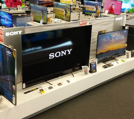 Televisori Sony esposti in un negozio di elettronica, con vari modelli su uno scaffale bianco.