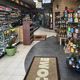 Cozy convenience store interior with shelves of products and a "Welcome" mat at the entrance.