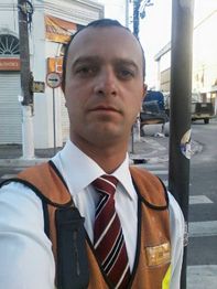 Pessoa de colete laranja e gravata em rua urbana durante o dia.