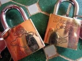 Deux cadenas dorés sur une table en carreaux verts, gravés avec "Ange" et "Démon".