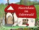 Cartoon-Hasenhaus mit rotem Dach im Odenwald, vier Hasen schauen aus Fenstern und Türen.
