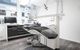 Modern dental office with chair, monitor, and equipment in a clean, bright setting.