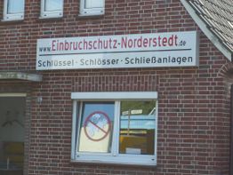 Backsteinfassade mit Schild: "Einbruchschutz-Norderstedt.de - Schlüssel, Schlösser, Schließanlagen".