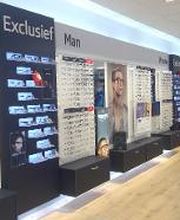 Brillenwinkelinterieur met displays voor exclusieve herenbrillen en stoelen voor oogmetingen.
