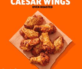 Alitas de pollo asadas sobre papel, fondo naranja, texto: "Caesar Wings", "Little Caesars".