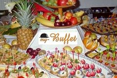 Ein vielfältiges Buffet mit Früchten und Snacks, dekorativ angerichtet und reichlich ausgestattet.