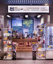 Geschäft für Schuhreparaturen und Schlüsselservice mit Taschen und Zubehör im Schaufenster.