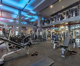 Academia moderna com diversos equipamentos de musculação em um ambiente bem iluminado.