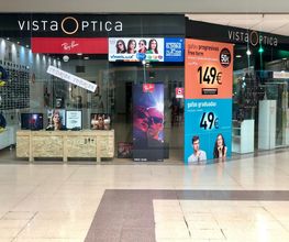 Tienda de óptica con ofertas de gafas progresivas y graduadas en un centro comercial.