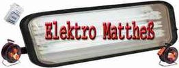 Leuchtreklame mit rotem Text "Elektro Matthes", umgeben von Steckern und Kabeltrommeln.