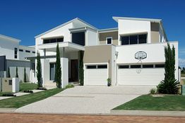 Modern two-story house with a white facade, driveway, and a basketball hoop.