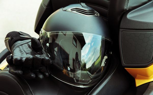 Ein Motorradhelm liegt auf dem Sattel eines Motorrads mit gelben Details.