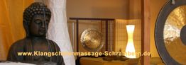 Buddha-Statue, Gongs und Lampe in einem harmonisch dekorierten Raum, Schriftzug über Webseite.